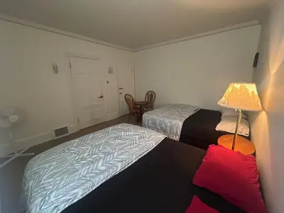 a bedroom with two beds and a lamp and a chair at Vancouver Guest House - Airport 10 Min - Free Parking & Fast Wi-Fi in Vancouver