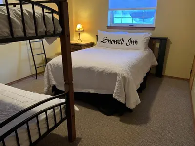 a bedroom with two bunk beds and a window at Snowed Inn Chalet by Fernie Central Reservations Right on the Slopes in Fernie