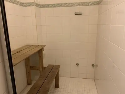 a tiled shower with a wooden bench in a bathroom at Snowed Inn Chalet by Fernie Central Reservations Right on the Slopes in Fernie