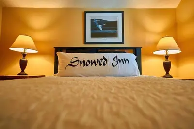 a bedroom with a bed with a pillow with the wordmoose sum on it at Snowed Inn Chalet by Fernie Central Reservations Right on the Slopes in Fernie