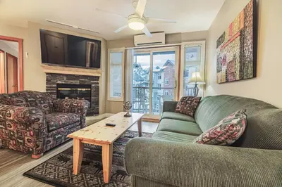 a living room with a couch and a table at Cozy 2BR-5BD Suite - Mountain Views - Htd Parking in Canmore