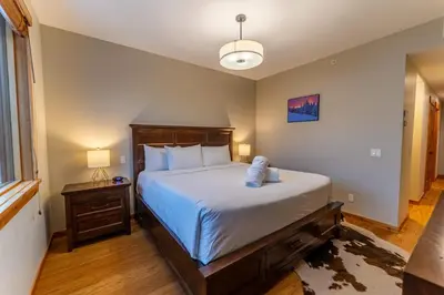 a bedroom with a large bed and a window at Alpine Chic - two-story mtn escape near downtown in Canmore