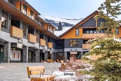 a building with a courtyard with benches in the snow at Alpine Chic - two-story mtn escape near downtown in Canmore