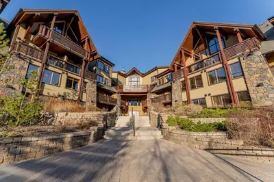 a road in front of a large building at Rundle Range Retreat Lux Mtn View Condo near dt in Canmore