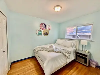 a bedroom with a bed and a window at Charming Bright 3BR House - Upper Level Suite in Burnaby