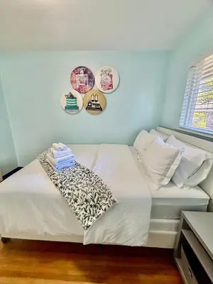 a bed in a room with plates on the wall at Charming Bright 3BR House - Upper Level Suite in Burnaby