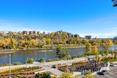 a group of people standing next to a river at Stylish & Romantic Riverside Stay in Downtown in Calgary