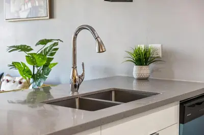 a kitchen counter with a sink and some plants at Stylish & Romantic Riverside Stay in Downtown in Calgary