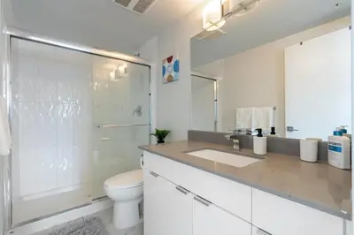 a white bathroom with a toilet and a sink at Cozy And Modern 2 Bedroom Along Bow River in Downtown in Calgary