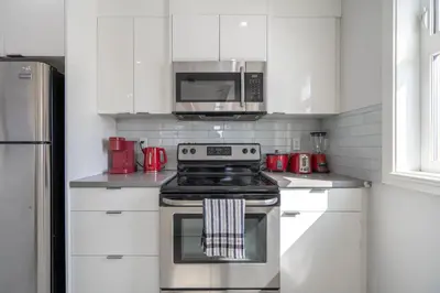 a kitchen with a stove and a microwave at Cozy And Modern 2 Bedroom Along Bow River in Downtown in Calgary