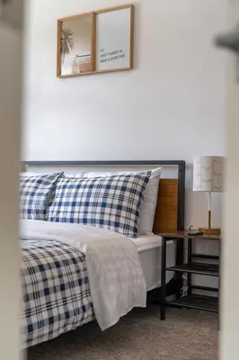 a bed with blue and white pillows and a table at Cozy And Modern 2 Bedroom Along Bow River in Downtown in Calgary
