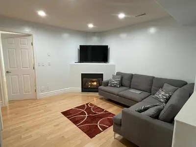 a living room with a couch and a fireplace at Spacious 2 BED close to BEACH, Highway & US BORDER in Surrey