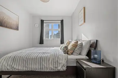 a white bedroom with a bed and a window at Waterfront 2 Beds And 2 Bath Downtown Urban Escape in Calgary