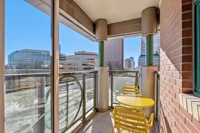 a balcony with a table and chairs and a view of the city at Waterfront 2 Beds And 2 Bath Downtown Urban Escape in Calgary