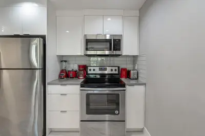a kitchen with a stove and a microwave at Vibrant Stylish, Cozy Waterfront Downtown in Calgary