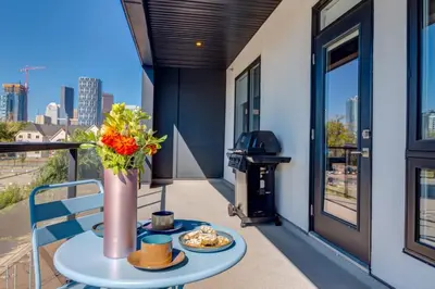 a balcony with a table with a vase of flowers at Lovely 3BR unit in the heart of Calgary in Calgary