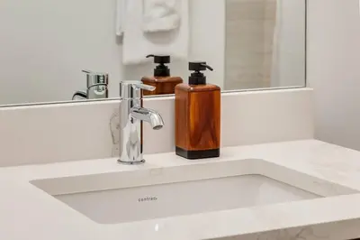 a bathroom sink with two soap dispensers on it at Lovely 3BR unit in the heart of Calgary in Calgary