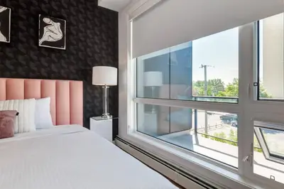 a bedroom with a bed and a large window at Modern 3BR unit in the heart of Calgary in Calgary