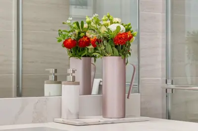 a bathroom with two vases with flowers on a sink at Modern 3BR unit in the heart of Calgary in Calgary