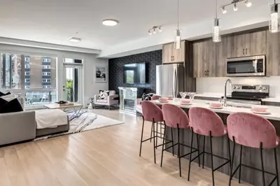 a kitchen and living room with a table and chairs at Modern 3BR unit in the heart of Calgary in Calgary
