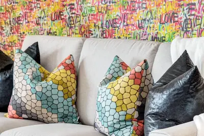a white couch with pillows on it with graffiti at Cozy 3BR unit with Arcade in the heart of Calgary in Calgary