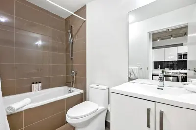 a bathroom with a toilet and a sink and a tub at Modern 1BR City Escape with Balcony near DT Calgary in Calgary