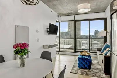 a living room with a table and chairs and a large window at Spacious and Stylish Modern Condo in Calgary in Calgary