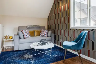 a living room with a couch and a table and a chair at Cozy and Stylish Stay in Mountain View Condo in Canmore