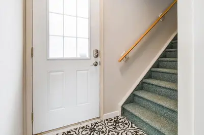 a white door in a hallway with stairs at Cozy and Stylish Stay in Mountain View Condo in Canmore