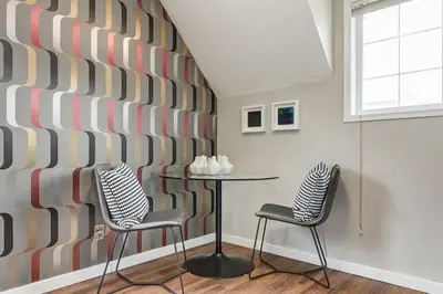 a room with a table and two chairs and a wall at Cozy and Stylish Stay in Mountain View Condo in Canmore