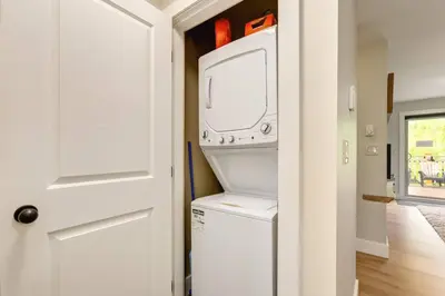 a laundry room with a washer and dryer next to a door at Rockies Escape Skiing Hiking and Private Hot Tub in Golden