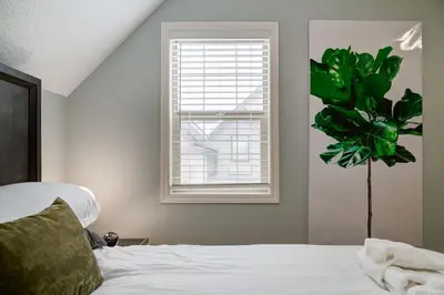 a bedroom with a bed and a window and a plant at The Cutest Condo in Canmore and Banff in Canmore