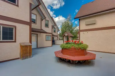 a patio with a flower pot with red flowers in it at Cozy getaway for exploring Canmore and Banff in Canmore