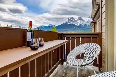 a balcony with a table and a bottle of wine at The Most Perfect Stay in Canmore with Mountain View in Canmore