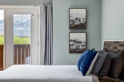 a bedroom with a large bed and a window at Stunning Mountain View Cozy Studio for Small Grp in Canmore
