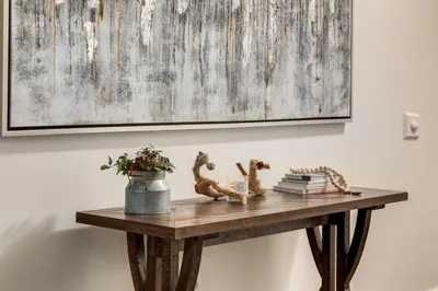 a wooden table with a painting on the wall at Peaceful Mountain Getaway in Canmore near Banff in Canmore