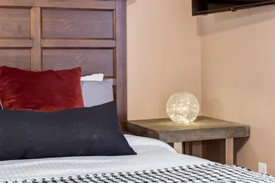 a bedroom with a bed and a table with a lamp at Peaceful Mountain Getaway in Canmore near Banff in Canmore