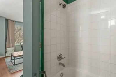 a bathroom with a shower with white tiles at Charming and Stylish renovated Condo near Banff in Canmore