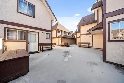 an empty parking lot in front of a house at Charming Condo In The Heart Of Canmore in Canmore