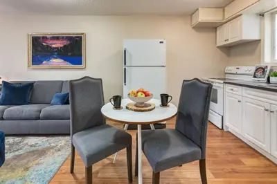 a kitchen and living room with a table and chairs at Cozy Condo in the Heart of Canmore in Canmore