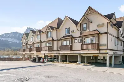 a large apartment building with balconies on a street at Stylish Getaway in the Heart of Canmore near Banff in Canmore