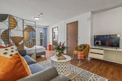 a living room with a couch and a tv at Stylish Getaway in the Heart of Canmore near Banff in Canmore