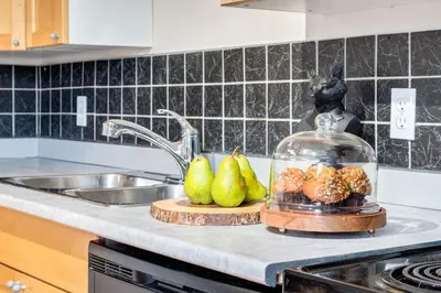 a kitchen counter with a dish of pears and a sink at Delightful 2BR Mountain Escape in Canmore in Canmore