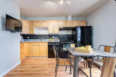 a kitchen with a table and a black refrigerator at Delightful 2BR Mountain Escape in Canmore in Canmore