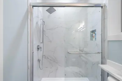 a bathroom with a shower with a glass door at Modern 6BR Home - Perfect for Groups & Families in Vancouver