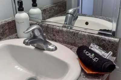 a bathroom sink with a faucet and a mirror at Downtown Edmonton Suite: 5-Min Drive to Rogers in Edmonton