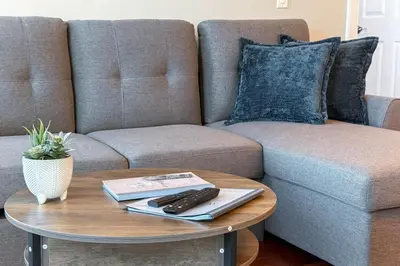 a coffee table with a remote control on top of a couch at Downtown Edmonton Suite: 5-Min Drive to Rogers in Edmonton