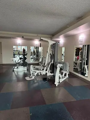 a gym with several tread machines and mirrors at Downtown Edmonton Suite: 5-Min Drive to Rogers in Edmonton