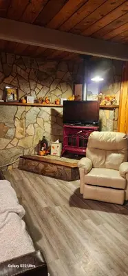a living room with a couch and a stone wall at Brown Family Farm in Grand Forks