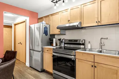 a kitchen with wooden cabinets and a stainless steel refrigerator at Mesmerizing 2BR Retreat Made For You in Canmore